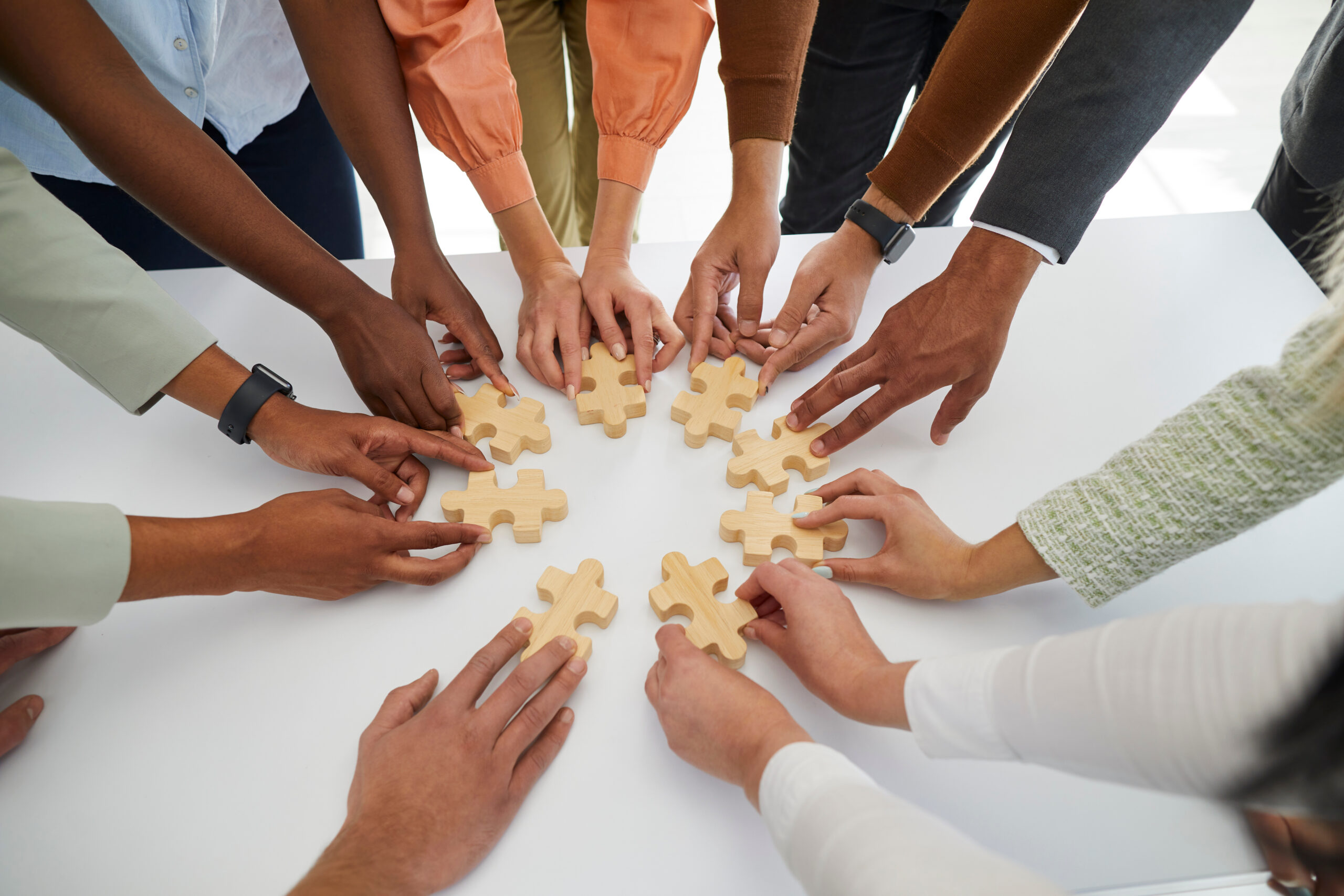 Diverse employees connect jigsaw puzzle pieces